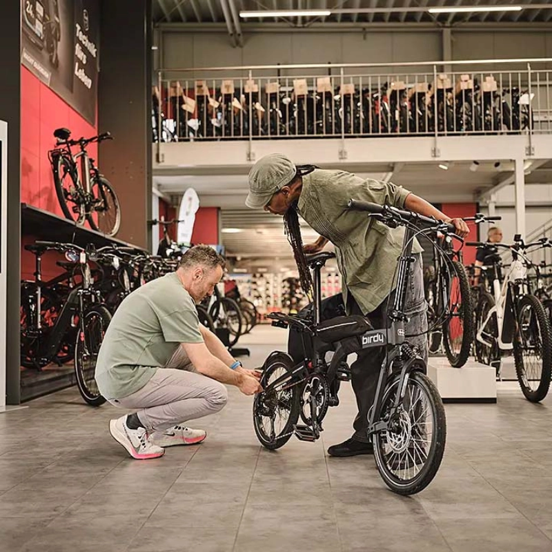 Ein Fachhändler berät eine Kundin mit Klapprad Ein Fachhändler berät eine Kundin mit Klapprad